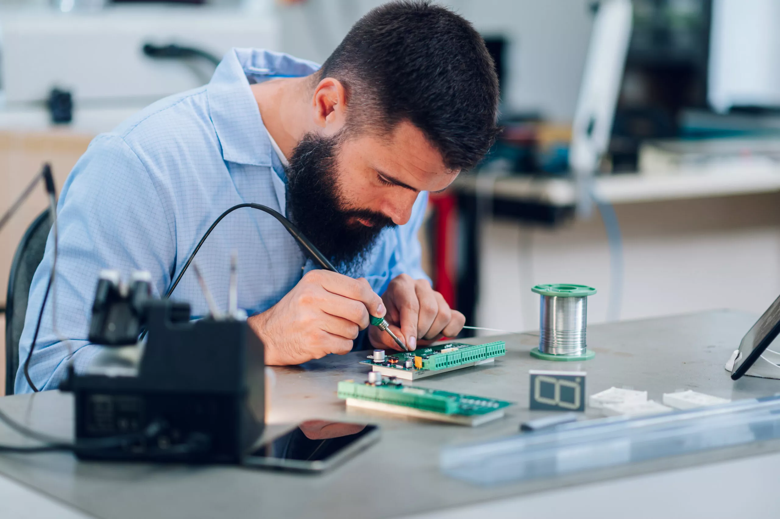 Electronics engineer working in a workshop with tin soldering parts
